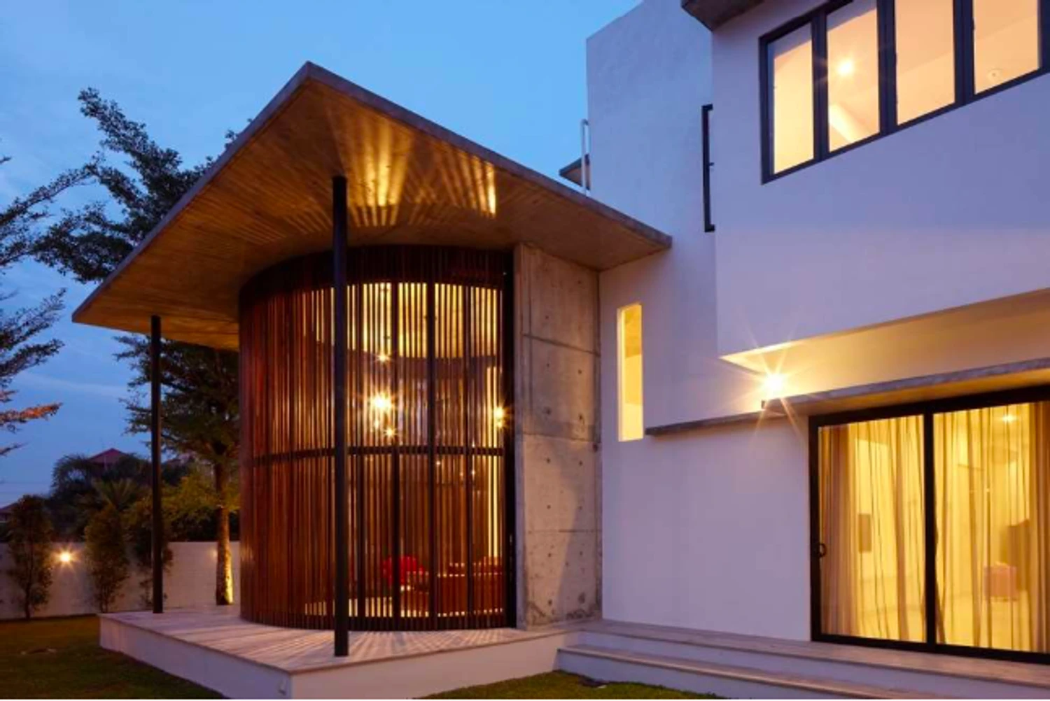 Ara Damansara bungalow with warm lighting and distinctive curved timber screen
